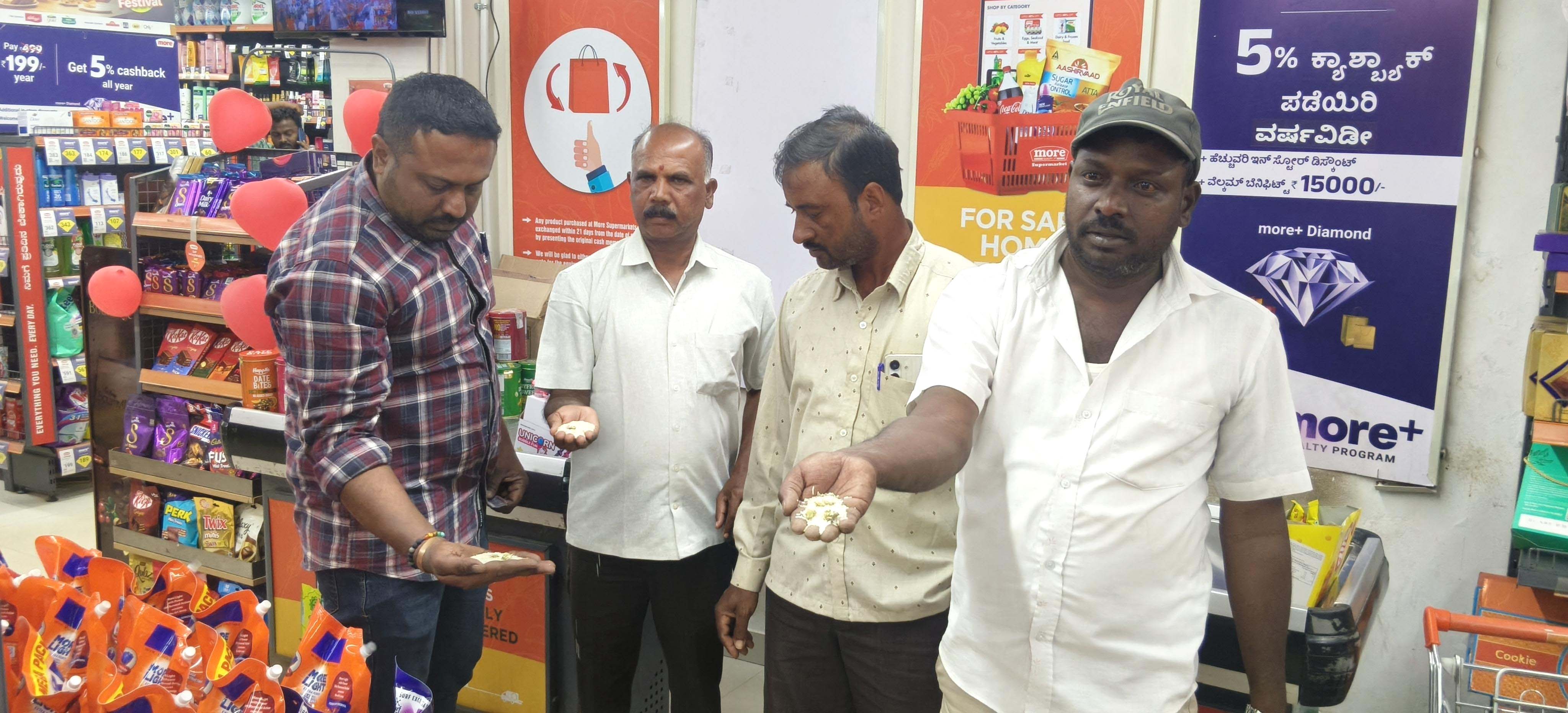 ಅಕ್ಕಿಯಲ್ಲಿ ಹುಳು ಆಗಿರುವುದನ್ನು ತೋರಿಸುತ್ತಿರುವ ಗ್ರಾಹಕರು.