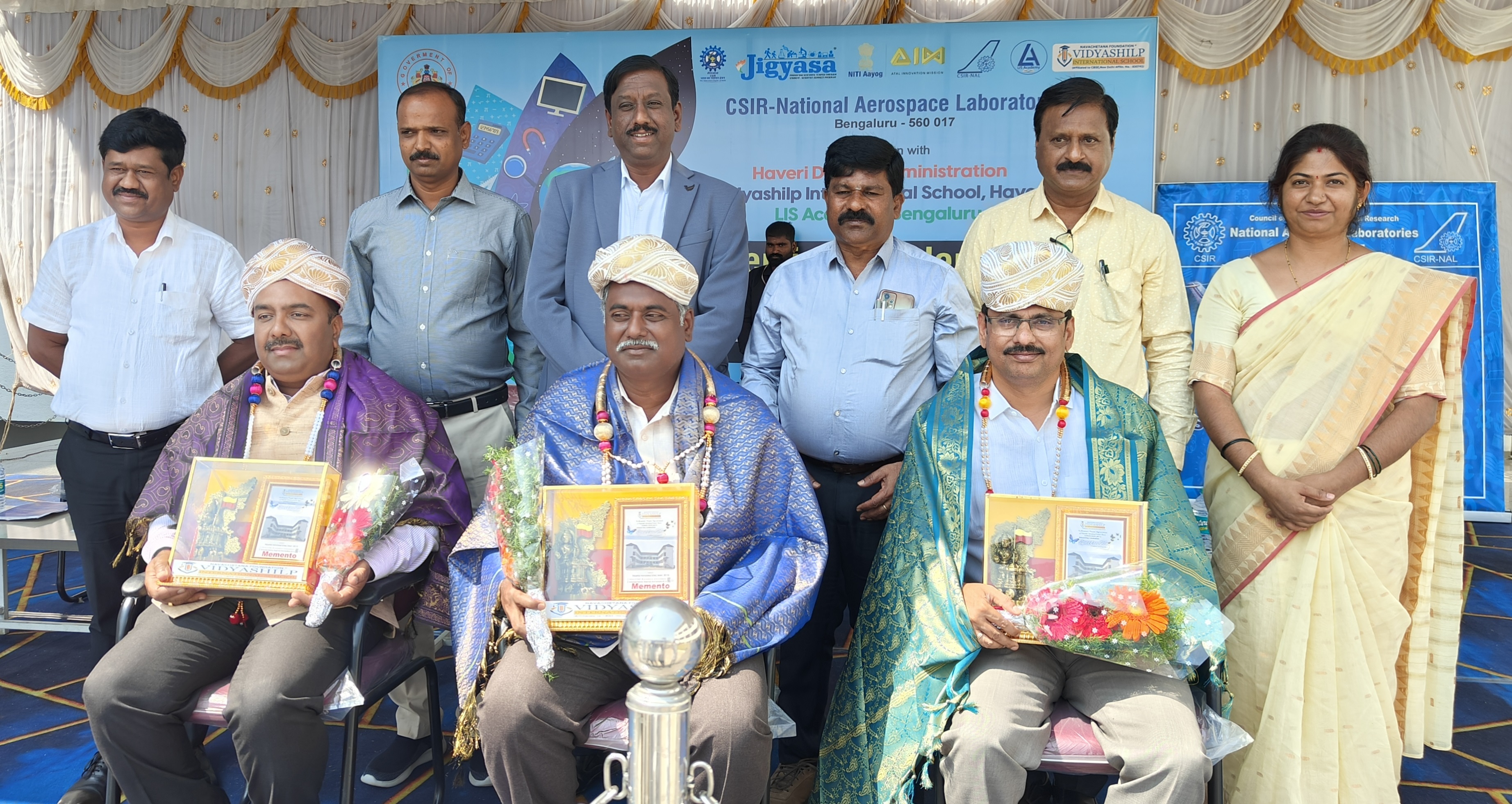 ಹಾವೇರಿಯಲ್ಲಿ ಬುಧವಾರ ಹಮ್ಮಿಕೊಂಡಿದ್ದ ಜಿಜ್ಞಾಸ ಕಾರ್ಯಕ್ರಮದಲ್ಲಿ ವಿಜ್ಞಾನಿಗಳಾದ ವಿ.ಪಿ.ಎಸ್. ನಾಯ್ಡು ಗಿರೀಶ ಯನಮಶೆಟ್ಟಿ ಮುಖ್ಯಸ್ಥ ಶಿವರಾಮ್ ಬಿ.ಎಸ್. ಅವರನ್ನು ಸನ್ಮಾನಿಸಲಾಯಿತು