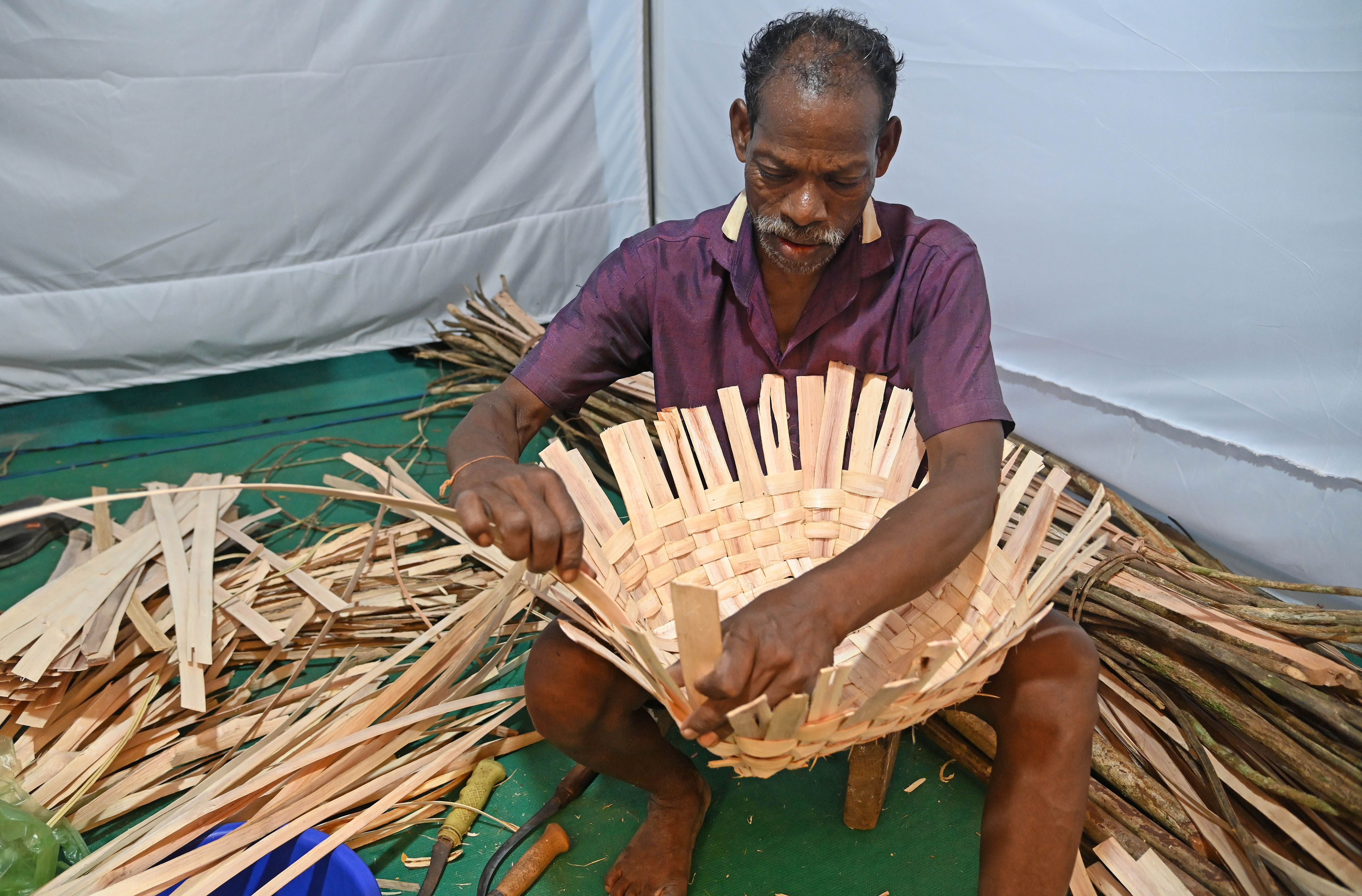  ಬುಟ್ಟಿ ಹೆಣಿಯುತ್ತಿರುವ ಕೊರಗ ಸಮುದಾಯದ ವ್ಯಕ್ತಿ