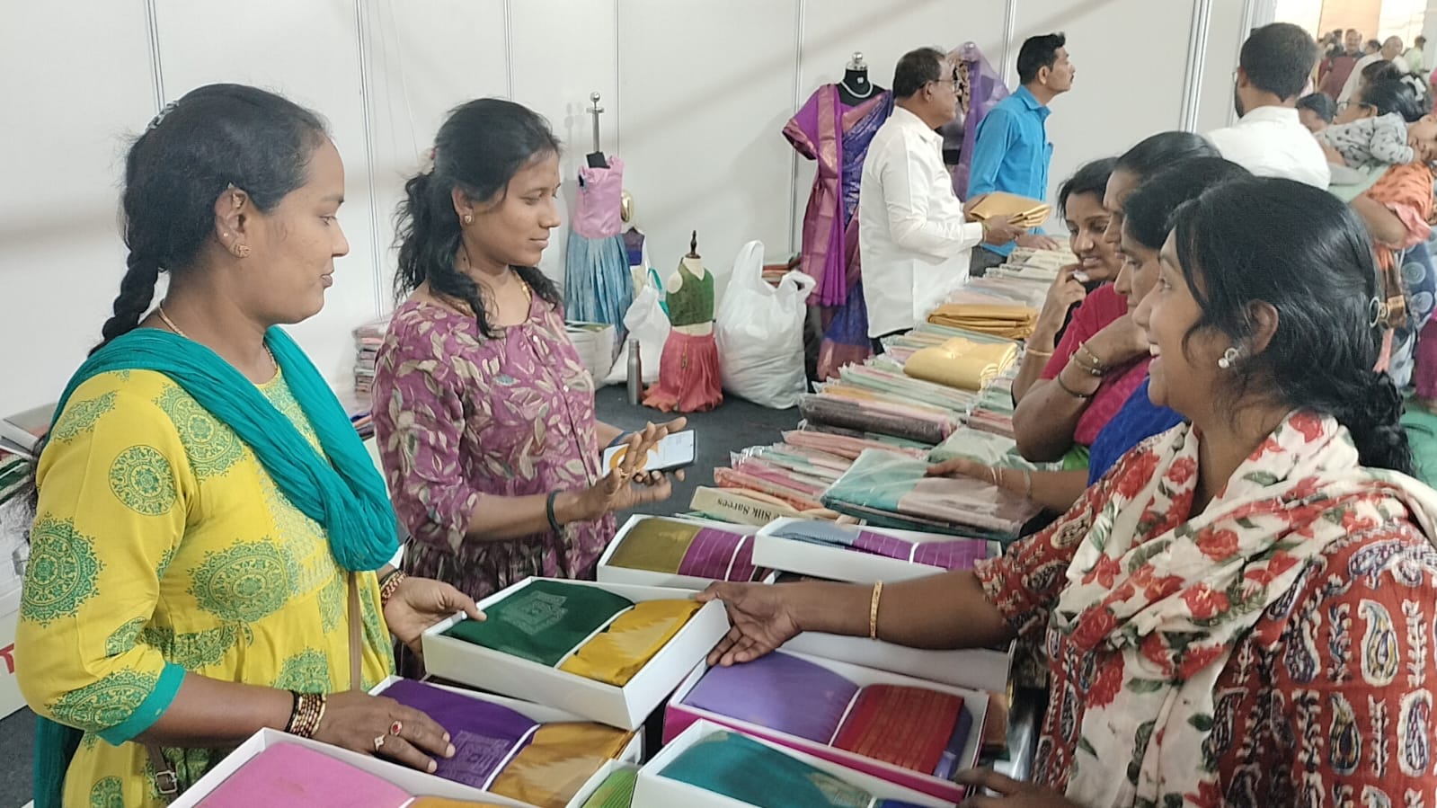ಸ್ಥಳೀಯ ನೇಕಾರರು ನೇಯ್ದಿರುವ ಸೀರೆಗಳ ಖರೀದಿಯಲ್ಲಿ ನಿರತರಾಗಿರುವ ಮಹಿಳೆಯರು