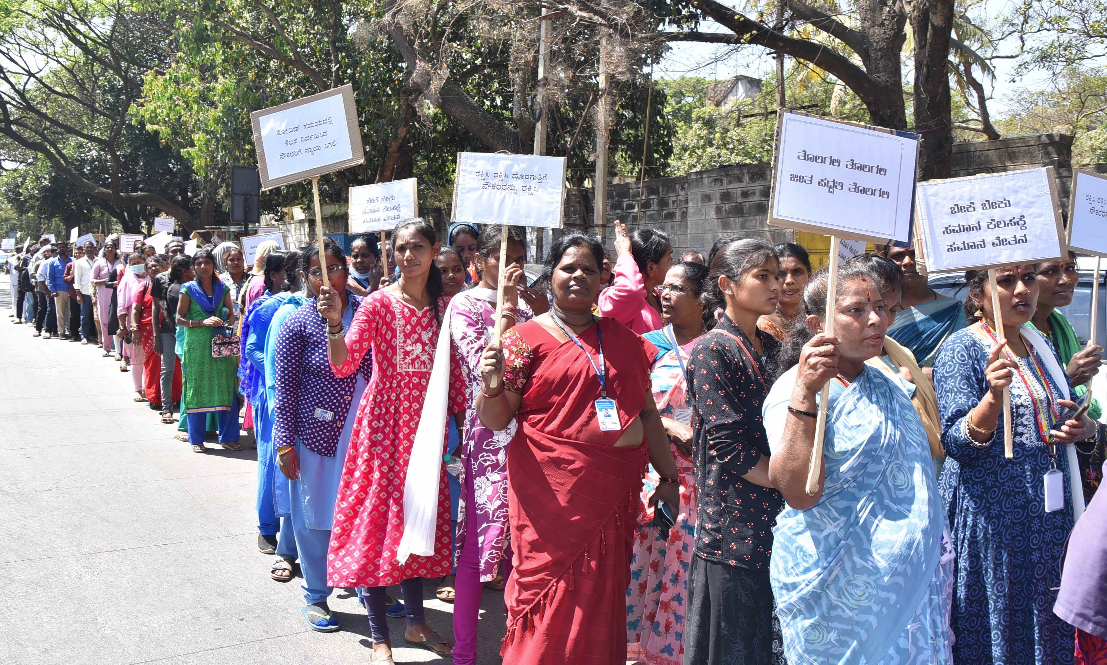 ತುಮಕೂರಿನಲ್ಲಿ ಶುಕ್ರವಾರ ವಿವಿಧ ಬೇಡಿಕೆಗಳ ಈಡೇರಿಕೆಗೆ ಆಗ್ರಹಿಸಿ ಆರೋಗ್ಯ ಇಲಾಖೆ ಹೊರ ಗುತ್ತಿಗೆ ನೌಕರರು ಪ್ರತಿಭಟನಾ ಮೆರವಣಿಗೆ ನಡೆಸಿದರು