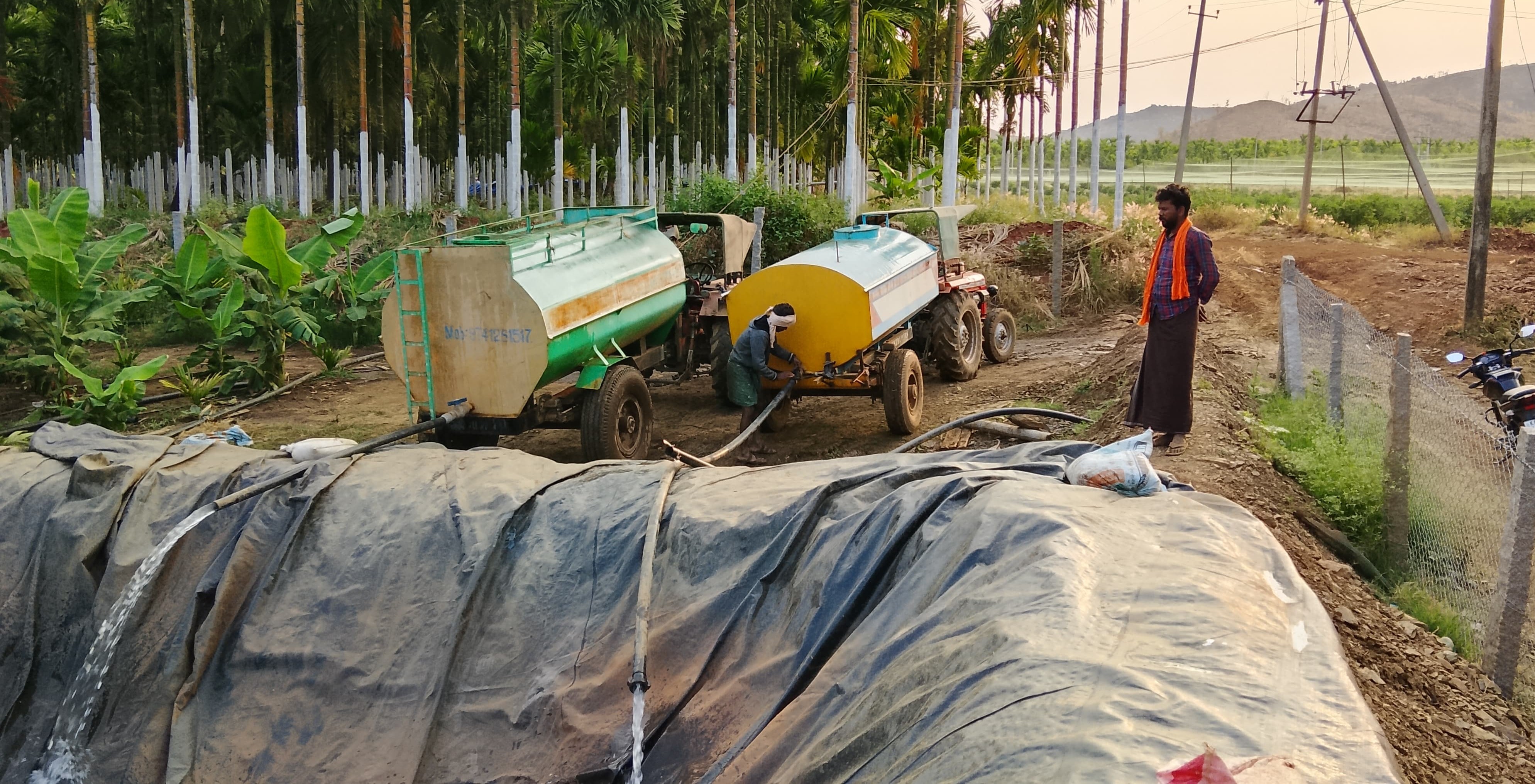 ತೋಟಗಳಲ್ಲಿರುವ ತೊಟ್ಟಿಗಳಿಗೆ ಟ್ಯಾಂಕರ್ ನೀರು ತುಂಬಿಸುತ್ತಿರುವ ದೃಶ್ಯ