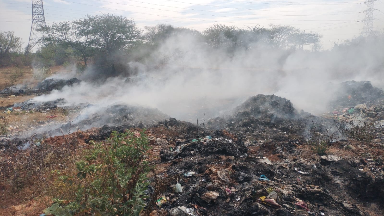 ಹೊಸಕೋಟೆ ಹಸಿಗಾಳ ಕೆರೆಯಲ್ಲಿ ತ್ಯಾಜ್ಯಕ್ಕೆ ಬೆಂಕಿ ಹಚ್ಚಿರುವುದು