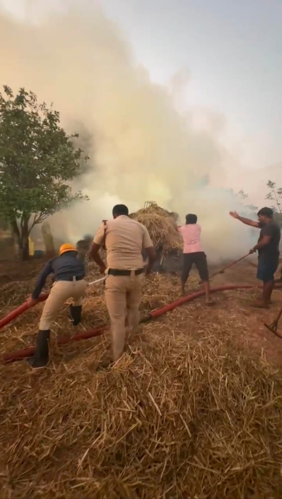 ಅಗ್ನಿಶಾಮಕ ಸಿಬ್ಬಂದಿ ಹುಲ್ಲಿನ ಬಣವೆ ಆರಿಸುತ್ತಿರುವುದು