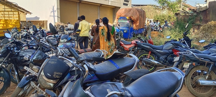 ಸಂತೆ ಮಾರುಕಟ್ಟೆ ರಸ್ತೆಯಲ್ಲಿ ನಿಲ್ಲಿಸಿರುವ ದ್ವಿಚಕ್ರ ವಾಹನಗಳು. ಅವುಗಳ ನಡುವೆಯೇ ನಡೆದುಕೊಂಡು ಹೋಗುತ್ತಿರುವ ಜನ 