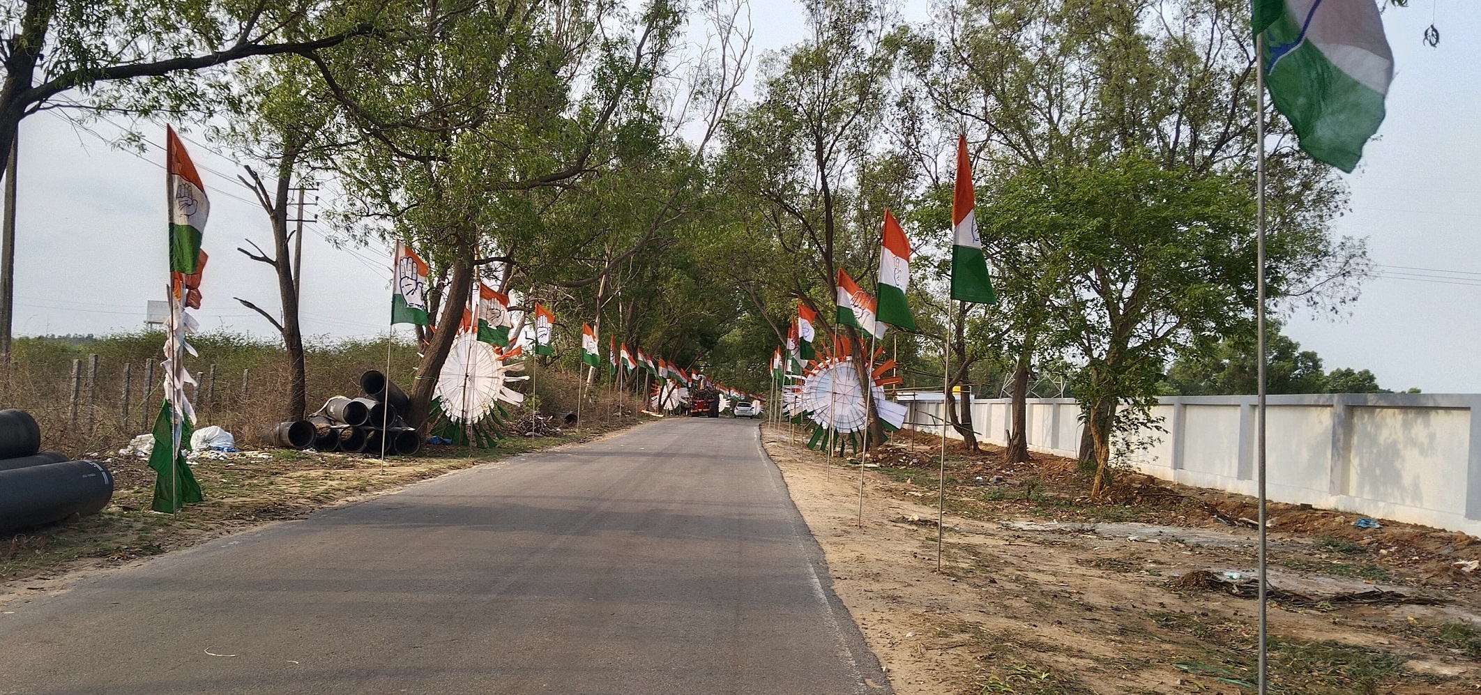 ಇಂಡ್ಲವಾಡಿ ರಸ್ತೆಯಲ್ಲಿ ಕಾಂಗ್ರೆಸ್‌ ಬಾವುಟಗಳು ರಾರಾಜಿಸುತ್ತಿರುವುದು