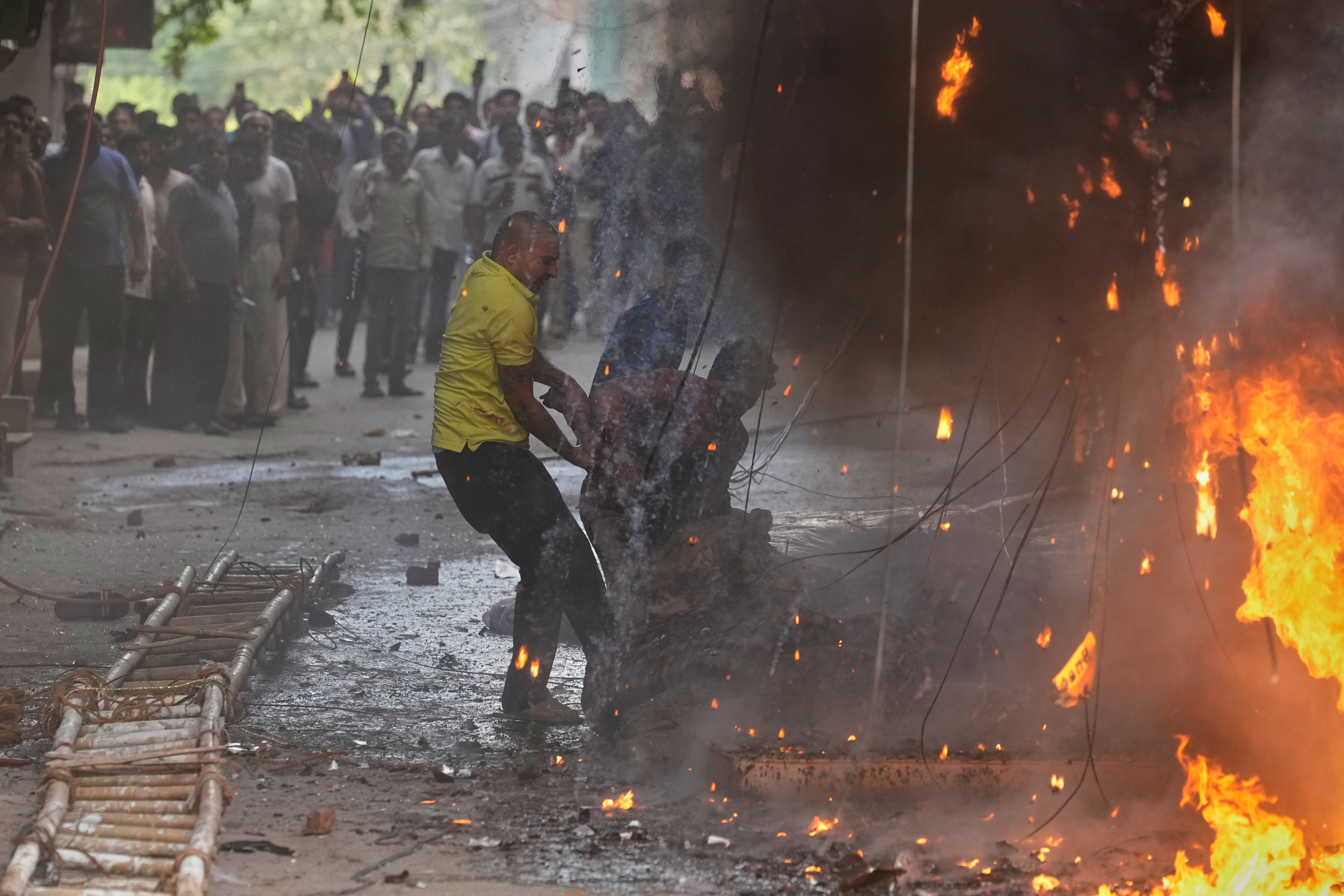 ಬೆಂಕಿ ಅವಘಡದಲ್ಲಿ ಸಿಲುಕಿದ್ದ ಕೆಲ ಜನರನ್ನು ಸ್ಥಳೀಯರು ರಕ್ಷಿಸಿದರು –ಎಪಿ/ಪಿಟಿಐ ಚಿತ್ರ 