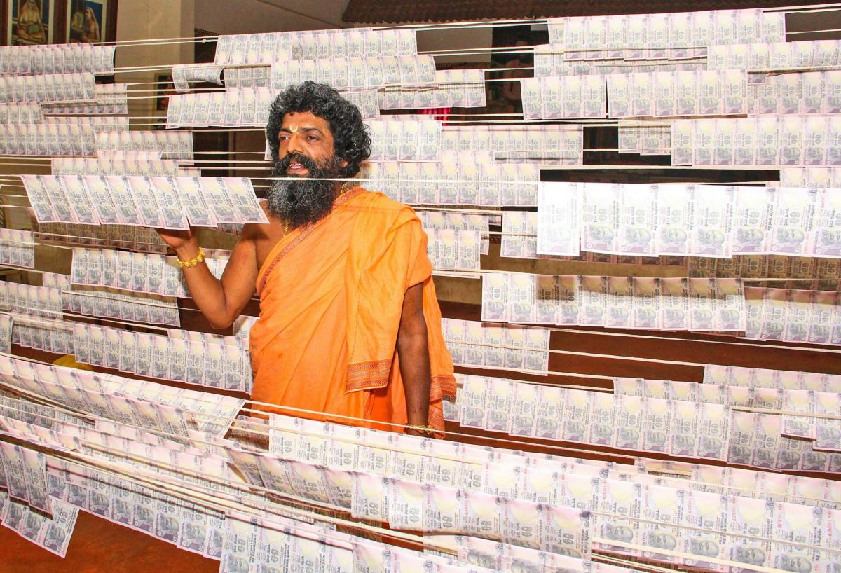 ಕಲಾವಿದರಿಗೆ ನೀಡಲು ಸಿದ್ಧಪಡಿಸಿರುವ ನೋಟುಗಳ ಹಾರಗಳೊಂದಿಗೆ ಶೀರೂರು ಮಠದಲಕ್ಷ್ಮೀವರತೀರ್ಥರು (ಚಿತ್ರ: ಪ್ರಜಾವಾಣಿ ಸಂಗ್ರಹ, 12/09/17)