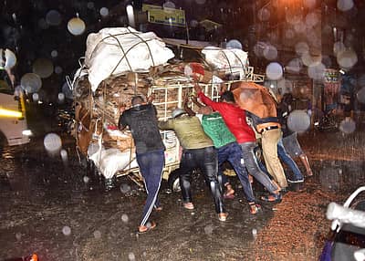 ಮಂಗಳವಾರ ಸಂಜೆ ಸುರಿದ ಮಳೆಗೆ ಬೆಂಗಳೂರಿನ ವೀರಭದ್ರನಗರ ವೃತ್ತದಲ್ಲಿ ಮ್ಯಾನ್‌ಹೋಲ್‌ಗೆ ಸಿಲುಕಿದ ಗೂಡ್ಸ್ ವಾಹನವನ್ನು ತಳ್ಳುತ್ತಿದ್ದ ಪೊಲೀಸ್‌ ಸಿಬ್ಬಂದಿ ಹಾಗೂ ಜನರು