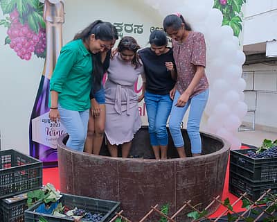ದ್ರಾಕ್ಷಿಯನ್ನು ತುಳಿಯುವ ಮೂಲಕ ಸಾಂಪ್ರದಾಯಿಕ ವೈನ್ ತಯಾರಿಕೆಗೆ ಚಾಲನೆ ನೀಡಿದ ಯುವತಿಯರು. – ಚಿತ್ರ: ಮರಿಯಾ ಎಸ್ ಮತ್ತತ್ತಿಲ್