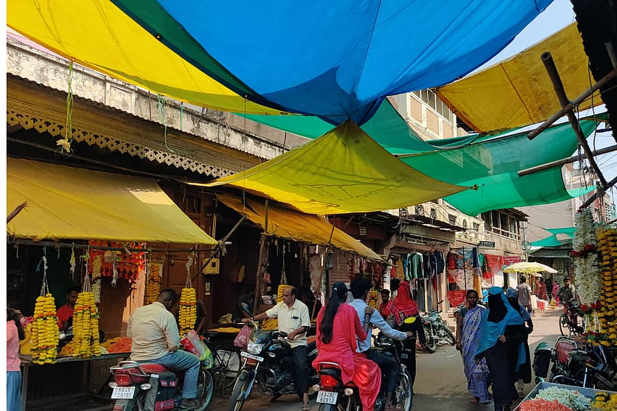 ಬನಹಟ್ಟಿಯ ಮಂಗಳವಾರ ಪೇಟೆಯ ಪ್ರಮುಖ ಬೀದಿಯಲ್ಲಿ ಹೂ ಮಾರಾಟಗಾರರು ಹೂವಿನ ರಕ್ಷಣೆಗಾಗಿ ಪ್ಲಾಸ್ಟಿಕ್ ಹೊದಿಕೆ ಹಾಕಿರುವುದು