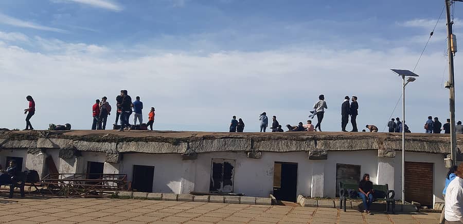 ನಂದಿಗಿರಿಧಾಮದ ಯೋಗ ನಂದೀಶ್ವರ ದೇಗುಲದ ಮುಂಭಾಗದ ಕಟ್ಟಡದ ಮೇಲೆ ಪ್ರವಾಸಿಗರು