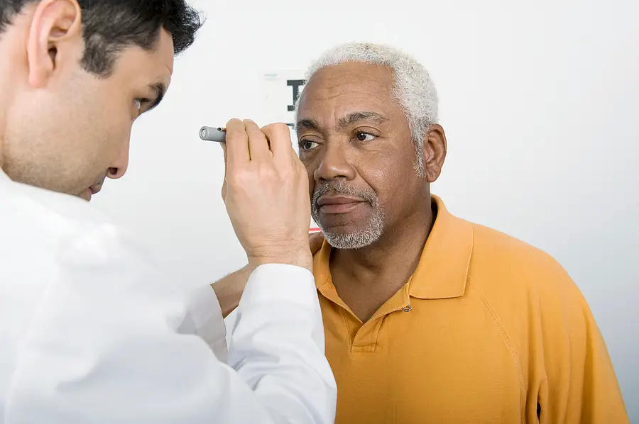 Mature male doctor testing an African American patient's eye in clinic
Male Doctor Testing Patient's Eye In Clinic