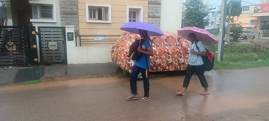 ರಾಮನಗರದಲ್ಲಿ ಮಂಗಳವಾರ ಸುರಿದ ಮಳೆಯಿಂದಾಗಿ ಛತ್ರಿ ಹಿಡಿದು ಸಾಗಿದ ವಿದ್ಯಾರ್ಥಿಗಳು