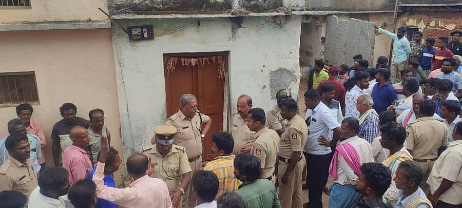 ಶ್ರೀನಿವಾಸಪುರ ತಾಲ್ಲೂಕಿನ ನಂಬಿಹಳ್ಳಿ ಗ್ರಾಮದಲ್ಲಿ ಕೊಲೆ ಆರೋಪಿ ಅಡಗಿ ಕುಳಿತಿದ್ದ ಮನೆ ಮುಂದೆ ನಿಂತಿರುವ ಪೊಲೀಸರು ಹಾಗೂ ಗ್ರಾಮಸ್ಥರು