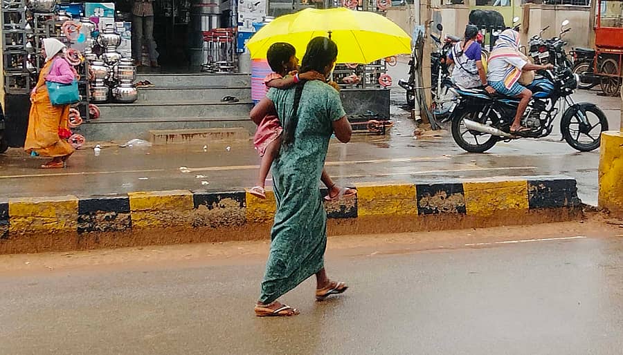 ಶ್ರೀನಿವಾಸಪುರದ ಎಂಜಿ ರಸ್ತೆಯಲ್ಲಿ ಸೋಮವಾರ ಮಹಿಳೆಯೊಬ್ಬರು ಮಳೆಯಲ್ಲಿ ಮಗುವನ್ನು ಕಂಕುಳಲ್ಲಿ ಹೊತ್ತು ಕೊಡೆ ಹಿಡಿದು ನಡೆದು ಹೋಗುತ್ತಿರುವುದು