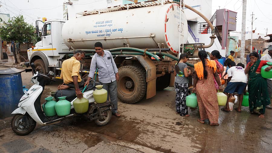 ಬಳ್ಳಾರಿ ತಾಲ್ಲೂಕಿನ ಹರಗಿನಡೋಣಿಯಲ್ಲಿ ಟ್ಯಾಂಕರ್‌ನಿಂದ ನೀರು ತುಂಬಿಸುತ್ತಿರುವ ಜನ. ತ್ರಿಚಕ್ರದಲ್ಲಿ ಬಂದಿದ್ದ ವಿಶೇಷ ಚೇತನರೊಬ್ಬರಿಗೆ ನೀರು ತುಂಬಿಸಲು ನೆರವಾಗುತ್ತಿರುವ ಚಾಲಕ.