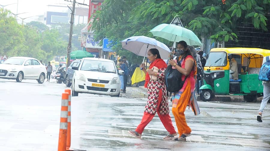 ತುಮಕೂರು ನಗರದಲ್ಲಿ ಬುಧವಾರ ಮಧ್ಯಾಹ್ನ ಛತ್ರಿ ಹಿಡಿದು ಮಳೆಯಲ್ಲೇ ಸಾಗಿದ ಮಹಿಳೆಯರು