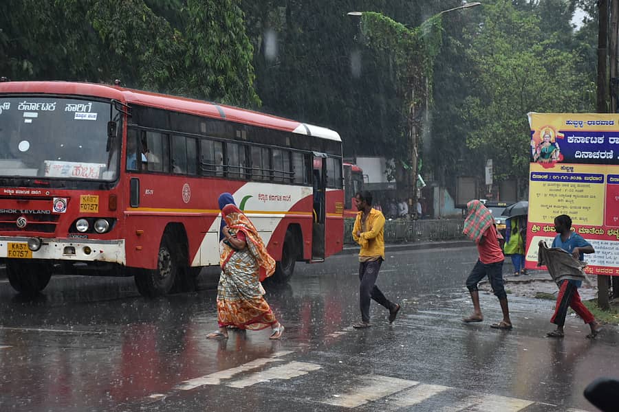ಹುಬ್ಬಳ್ಳಿಯ ಲ್ಯಾಮಿಂಗ್ಟನ್ ಬಸ್ ನಿಲ್ದಾಣದ ಬಳಿ ಸೋಮವಾರ ಪ್ರಯಾಣಿಕರು ಮಳೆಯಲ್ಲಿ ನೆನೆಯುತ್ತಲೇ ಬಸ್ ಹತ್ತಲು ಧಾವಿಸಿದರು