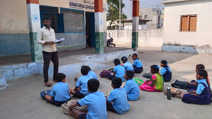 ಬಳ್ಳಾರಿ ಜಿಲ್ಲೆ ತೆಕ್ಕಲಕೋಟೆಯ ಸರ್ಕಾರಿ ಹಿರಿಯ ಪ್ರಾಥಮಿಕ ಶಾಲೆಯ ಕಟ್ಟಡ ಶಿಥಿಲಗೊಂಡಿದ್ದು, ಶಾಲಾ ಆವರಣದಲ್ಲಿ ವಿದ್ಯಾರ್ಥಿಗಳಿಗೆ ಶಿಕ್ಷಕರು ಪಾಠ ಮಾಡುತ್ತಿರುವುದು/ಪ್ರಜಾವಾಣಿ ಚಿತ್ರ– ಚಾಂದಬಾಷ
