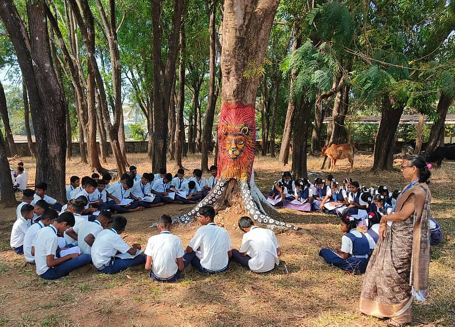 ಜೊಯಿಡಾ ತಾಲ್ಲೂಕಿನ ರಾಮನಗರದ ಸರ್ಕಾರಿ ಪ್ರೌಢಶಾಲೆಯ ಉದ್ಯಾನದಲ್ಲಿ ಚಿತ್ರ ರಚಿಸಲಾದ ಮರದ ಸುತ್ತ ಕೂತು ವಿದ್ಯಾರ್ಥಿಗಳು ಅಧ್ಯಯನದಲ್ಲಿ ನಿರತರಾಗಿರುವುದು