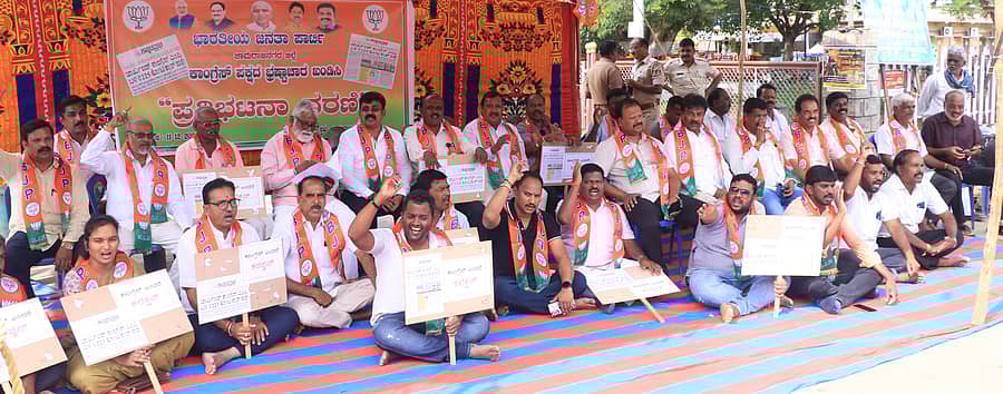 <div class="paragraphs"><p>ಕಾಂಗ್ರೆಸ್ ಭ್ರಷ್ಟಾಚಾರದಲ್ಲಿ ಮುಳುಗಿದೆ ಎಂದು ಆರೋಪಿಸಿ ಜಿಲ್ಲಾ ಬಿಜೆಪಿ ಘಟಕದ ಪದಾಧಿಕಾರಿಗಳು, ಮುಖಂಡರು ಚಾಮರಾಜನಗರದಲ್ಲಿ ಸೋಮವಾರ ಧರಣಿ ನಡೆಸಿದರು</p></div>