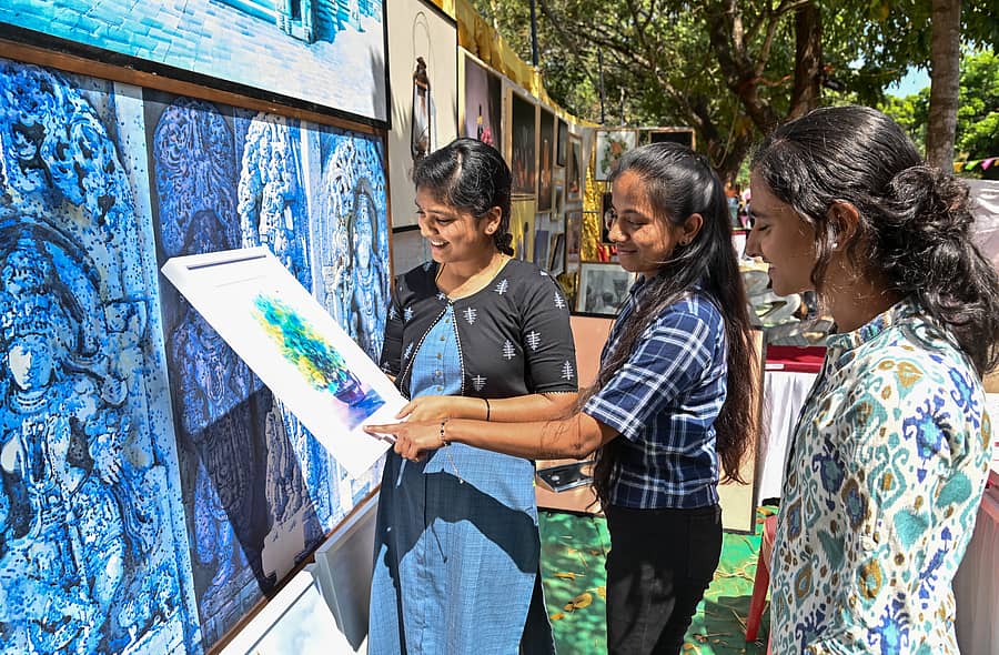 ಮೈಸೂರಿನ ಮಾನಸಗಂಗೋತ್ರಿ ಆವರಣದಲ್ಲಿ ಪ್ರವಾಸೋದ್ಯಮ ಇಲಾಖೆ ಹಾಗೂ ಜಿಲ್ಲಾ ಪ್ರವಾಸೋದ್ಯಮ ಅಭಿವೃದ್ಧಿ ಸಮಿತಿ ಶುಕ್ರವಾರ ಆರಂಭವಾದ ಮೈಸೂರು ಉತ್ಸವದ ‘ಚಿತ್ರಸಂತೆ’ಯಲ್ಲಿ ಕಲಾಕೃತಿಯನ್ನು ವೀಕ್ಷಿಸಿದ ಯುವತಿಯರು  ಪ್ರಜಾವಾಣಿ ಚಿತ್ರ