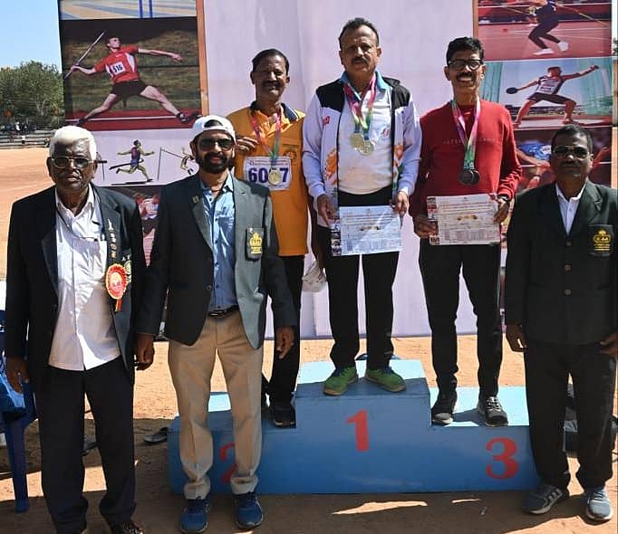 ಎರಡು ಚಿನ್ನದ ಪದಕದೊಂದಿಗೆ ಮಾದಪ್ಪ ಯೋಗೇಂದ್ರ (ಮಧ್ಯದಲ್ಲಿ ಇರುವವರು). ಅವರಿಗೆ ಅಥ್ಲೆಟಿಕ್ಸ್ ಮುಖ್ಯ ತಾಂತ್ರಿಕ ಅಧಿಕಾರಿ ಅಂಜನೇಯ, ಅಜೇಯ ಮತ್ತು ಆದಾಯ ತೆರಿಗೆ ಅಧಿಕಾರಿ ಮಹದೇವಯ್ಯ ಪ್ರಶಸ್ತಿ ವಿತರಿಸಿದರು.