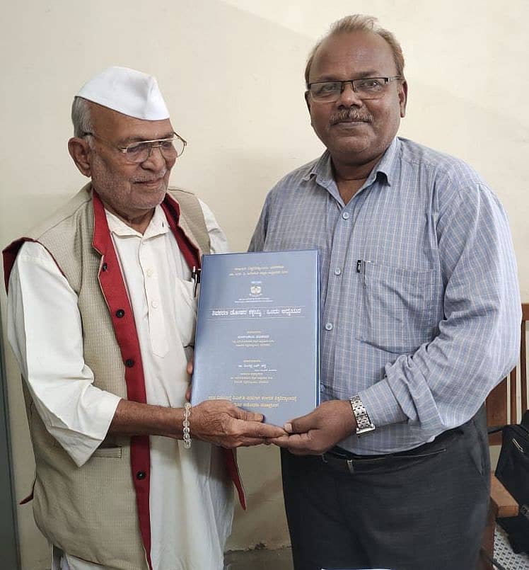 ದೊಡಮನಿ ಮಾರ್ಕಂಡೇಯ ಅವರು ಪಿ.ಎಚ್.ಡಿ ಮಹಾಪ್ರಬಂಧದ ಪ್ರತಿಯನ್ನು ಮಾರ್ಗದರ್ಶಕ ನಿಂಗಪ್ಪ ಮುದೇನೂರು ಅವರಿಗೆ ನೀಡಿದರು