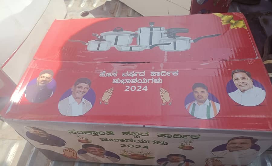 <div class="paragraphs"><p>ಮತದಾರರಿಗೆ ಹಂಚಿಕೆ ಮಾಡಿರುವ ಕುಕ್ಕರ್ ಬಾಕ್ಸ್ಗಳು</p></div>