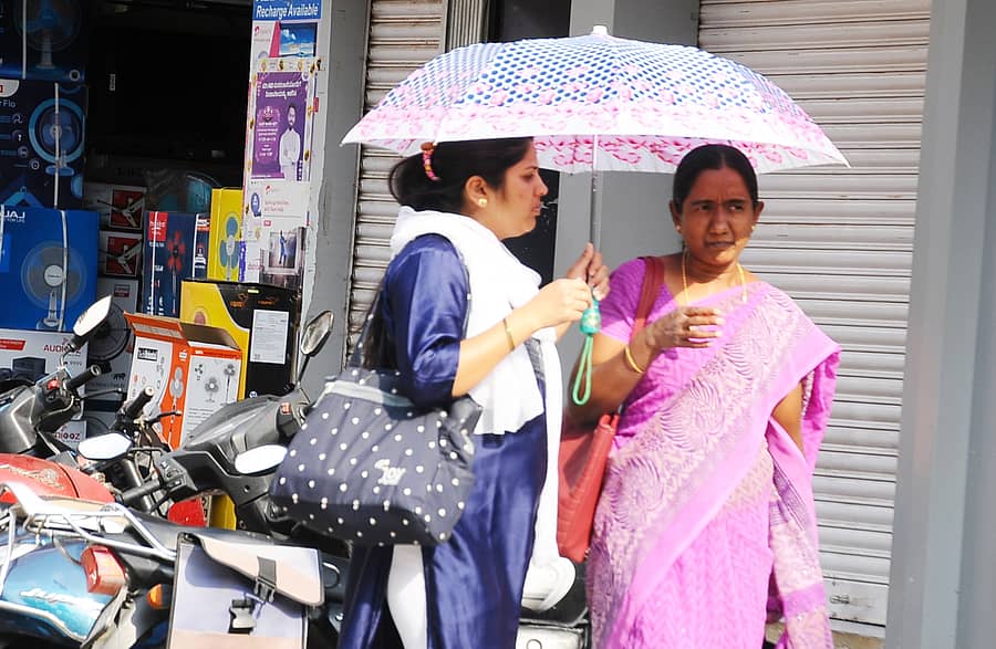 ತುಮಕೂರಿನಲ್ಲಿ ಭಾನುವಾರ ಬಿಸಿಲಿನಿಂದ ಪಾರಾಗಲು ಮಹಿಳೆಯರು ಕೊಡೆ ಹಿಡಿದು ಸಾಗಿದರು