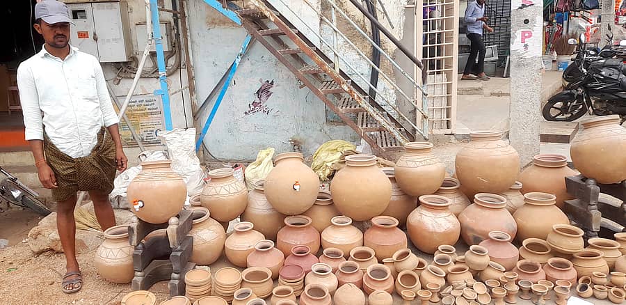 ಕಾರಟಗಿಯ ನವಲಿ ರಸ್ತೆಯ ದಲಾಲಿ ಬಜಾರ್ ತಿರುವು ಬಳಿ ಮಣ್ಣಿನ ಗಡಿಗೆಗಳ ಮಾರಾಟದಲ್ಲಿ ನಿರತರಾಗಿರುವ ಪನ್ನಾಪುರದ ಶರಣಪ್ಪ ಕುಂಬಾರ