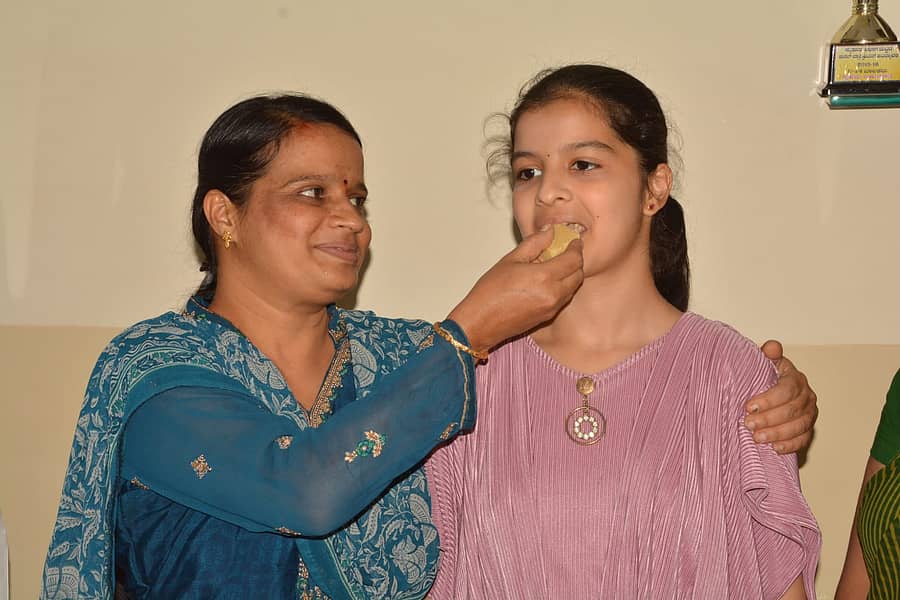 ಜಿಲ್ಲೆಗೆ ಪ್ರಥಮ ಸ್ಥಾನ ಪಡೆದ ಹಾಸನದ ಯುನೈಟೆಡ್ ಪ್ರೌಢಶಾಲೆಯ ಎಚ್.ಜಿ. ನಿಸರ್ಗ ಅವರಿಗೆ ತಾಯಿ ಸಿಹಿ ತಿನ್ನಿಸಿದರು