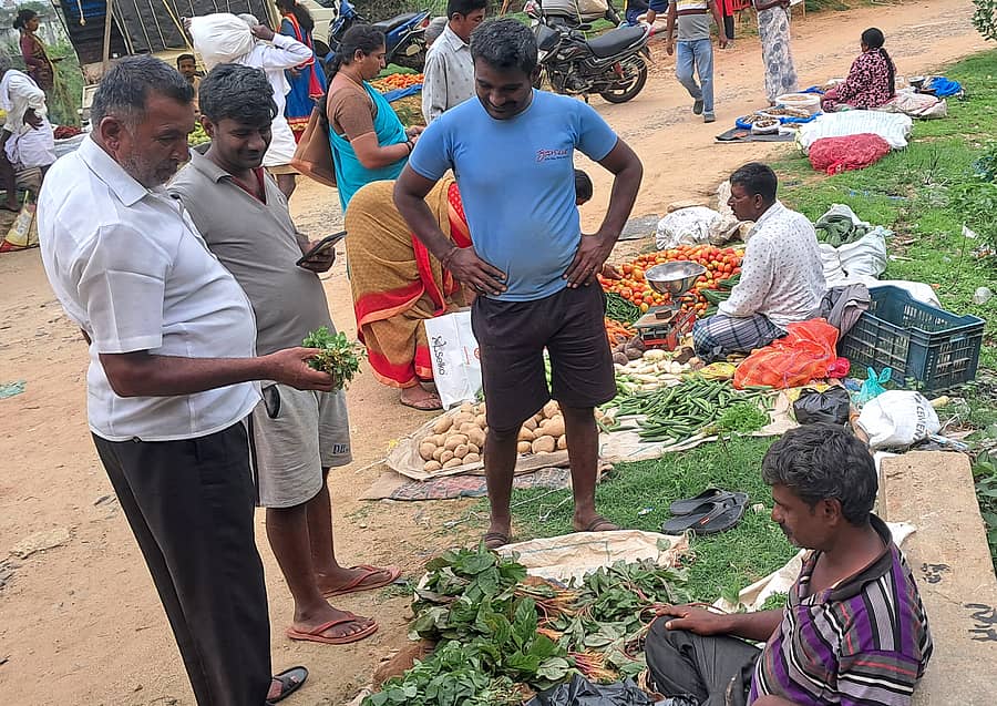 ಹಿರೀಸಾವೆಯಲ್ಲಿ ಭಾನುವಾರದ ಸಂತೆಯಲ್ಲಿ ಮೆಂತ್ಯೆ ಸೊಪ್ಪಿನ ಬೆಲೆ ಕೇಳುತ್ತಿರುವ ಗ್ರಾಹಕರು