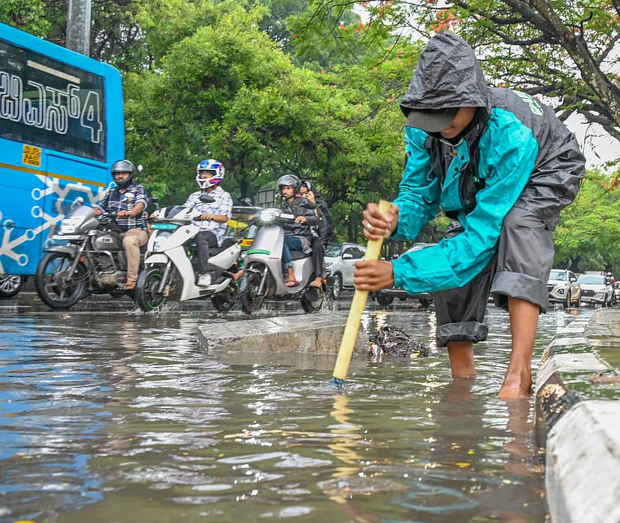 ಬೆಂಗಳೂರಿನ ಎಂ.ಚಿನ್ನಸ್ವಾಮಿ ಕ್ರೀಡಾಂಗಣದ ಬಳಿಯ ರಸ್ತೆಯಲ್ಲಿ ಸಂಗ್ರಹವಾಗಿದ್ದ ಮಳೆ ನೀರನ್ನು ಚರಂಡಿಗಳಿಗೆ ಸರಾಗವಾಗಿ ಹರಿಯುವಂತೆ ಮಾಡುತ್ತಿದ್ದ ಯುವಕ. -ಪ್ರಜಾವಾಣಿ ಚಿತ್ರ/ಕಿಶೋರ್ ಕುಮಾರ್ ಬೋಳಾರ್
