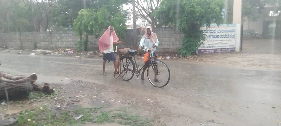 ಡಂಬಳ ಗ್ರಾಮದಲ್ಲಿ ಶನಿವಾರ ಮಧ್ಯಾಹ್ನ ಮಳೆ ಸುರಿಯುತ್ತಿರುವ ಸಮಯದಲ್ಲಿ ಕೃಷಿ ಚಟುವಟಿಕೆಗೆ ಹೋಗಿದ್ದ ರೈತರು ಮಳೆಯಲ್ಲಿ ತೊಯಿಸಿಕೊಂಡು ಬರುತ್ತಿರುವ ಚಿತ್ರಣ