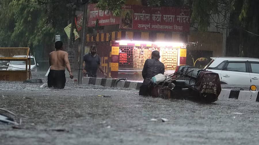 <div class="paragraphs"><p>ಭಾರಿ ನೀರು ತುಂಬಿರುವ ರಸ್ತೆಯಲ್ಲಿ ಸಂಚರಿಸಲು ಹರಸಾಹಸ ನಡೆಸುತ್ತಿರುವ ಜನರು</p></div>