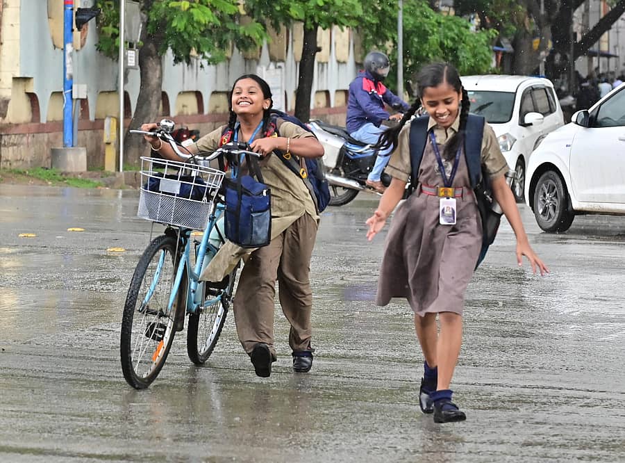 ದಾವಣಗೆರೆಯ ಪಿ.ಬಿ. ರಸ್ತೆಯಲ್ಲಿ ಗುರುವಾರ ಸಂಜೆ ಸುರಿಯುತ್ತಿದ್ದ ಮಳೆಯನ್ನು ಆಸ್ವಾದಿಸುತ್ತ ಸೈಕಲ್ ತಳ್ಳಿಕೊಂಡು ವಿದ್ಯಾರ್ಥಿನಿಯರು ರಸ್ತೆ ದಾಟಿದರು. –ಪ್ರಜಾವಾಣಿ ಚಿತ್ರ/ ಸತೀಶ್ ಬಡಿಗೇರ್