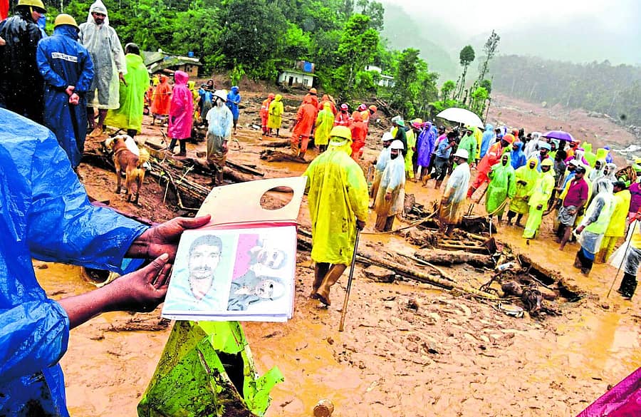 <div class="paragraphs"><p>ಚೂರಲ್ಮಲದಲ್ಲಿ ಶೋಧ ಕಾರ್ಯದ ನಡುವೆಯೇ ನಾಪತ್ತೆಯಾಗಿರುವ ಬಂಧುಗಳ ಫೋಟೊ ಹಿಡಿದು ವ್ಯಕ್ತಿಯೊಬ್ಬರು ಹುಡುಕಾಟ ನಡೆಸಿದ್ದರು </p></div>