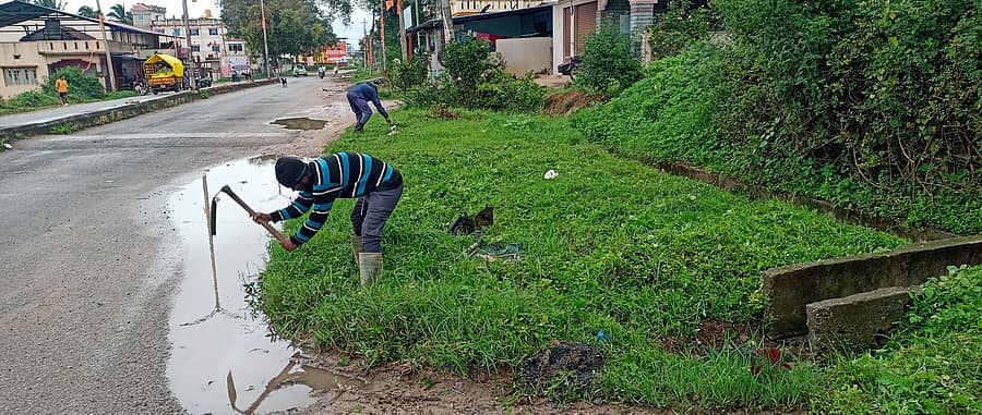ಆಲೂರು ಮುಖ್ಯ ರಸ್ತೆ ಬದಿಯಲ್ಲಿ ಸಂಗ್ರಹವಾಗಿದ್ದ ಕೊಳಚೆ ನೀರನ್ನು ಪ. ಪಂ. ಸಿಬ್ಬಂದಿಗಳು ಚರಂಡಿಗೆ ಹರಿಯುವಂತೆ ಕೆಲಸ ಮಾಡುತ್ತಿರುವುದು.