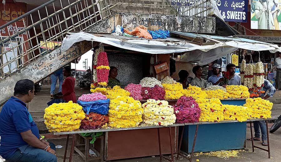 ಸೋಮವಾರಪೇಟೆ ಖಾಸಗಿ ಬಸ್ ನಿಲ್ದಾಣದಲ್ಲಿನ ಹೂವಿನ ವ್ಯಾಪಾರಿಗಳು ವ್ಯಾಪಾರಕ್ಕೆ ಕಾಯುತ್ತಿರುವುದು