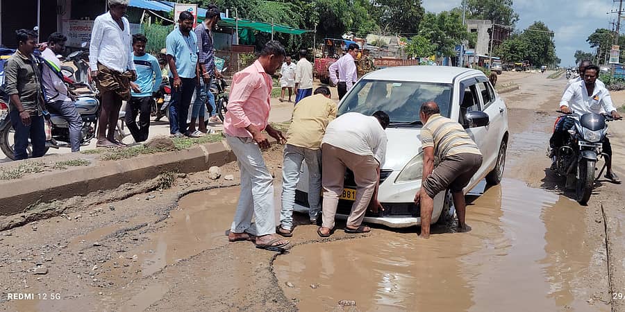 ಕವಿತಾಳದಲ್ಲಿ ರಾಜ್ಯ ಹೆದ್ದಾರಿ ಹದಗೆಟ್ಟಿದ್ದು ಗುರುವಾರ ಗುಂಡಿಯಲ್ಲಿ ಸಿಕ್ಕಿಕೊಂಡ ಅಧಿಕಾರಿಗಳ ಕಾರನ್ನು ಸಾರ್ವಜನಿಕರು ಮೇಲೆತ್ತಿದರು