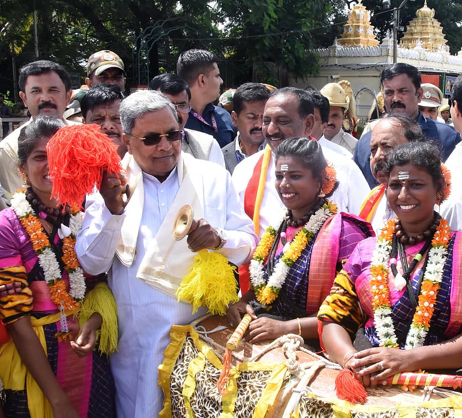 ಮೈಸೂರಿನ ಕೋಟೆ ಆಂಜನೇಯ ದೇವಾಲಯದ ಮುಂಭಾಗ ‘ಕನ್ನಡ ಸುವರ್ಣ ಸಂಭ್ರಮ ರಥ’ ಕ್ಕೆ ಚಾಲನೆ ನೀಡಿದ ಮುಖ್ಯಮಂತ್ರಿ ಸಿದ್ದರಾಮಯ್ಯ ಡೊಳ್ಳುಕುಣಿತ ಕಲಾವಿದರೊಂದಿಗೆ ತಾಳ ನುಡಿಸಿದರು