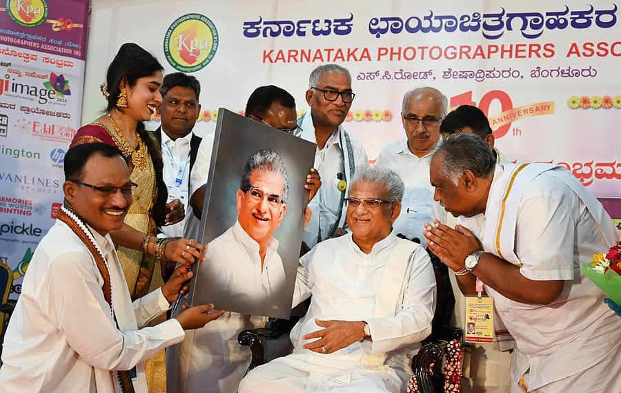 ನಗರದ ಅರಮನೆ ಮೈದಾನದಲ್ಲಿ ಶುಕ್ರವಾರ ನಡೆದ ಛಾಯಾಗ್ರಾಹಕರ ಸಂಘದ ದಶಮಾನೋತ್ಸವ ಸಂಭ್ರಮ ಮತ್ತು ‘ಡಿಜಿ ಇಮೇಜ್’ ಅಂತರರಾಷ್ಟ್ರೀಯ ವಸ್ತು ಪ್ರದರ್ಶನ ಕಾರ್ಯಕ್ರಮದಲ್ಲಿ ಧರ್ಮಸ್ಥಳದ ಧರ್ಮಾಧಿಕಾರಿ ಡಿ. ವೀರೇಂದ್ರ ಹೆಗ್ಗಡೆ ಅವರನ್ನು ಅವರದ್ದೇ ಭಾವಚಿತ್ರ ನೀಡಿ ಗೌರವಿಸಲಾಯಿತು. –ಪ್ರಜಾವಾಣಿ ಚಿತ್ರ
