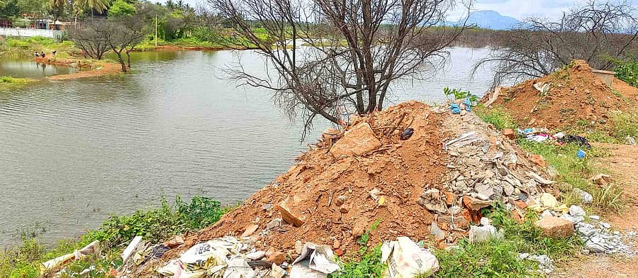 ವಿಜಯಪುರ ಅಮಾನಿಕೆರೆಯ ಏರಿ ಮೇಲಿನಿಂದ ಕಟ್ಟಡದ ಅವಶೇಷ ಕೆರೆಗೆ ಸುರಿದಿರುವುದು 