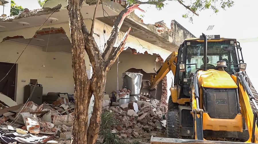 <div class="paragraphs"><p>ಜೈಪುರದ ದೇವಸ್ಥಾನದಲ್ಲಿ ಆರ್ಎಸ್ಎಸ್ ಕಾರ್ಯಕರ್ತರ ಮೇಲೆ ಹಲ್ಲೆ ನಡೆಸಿದ ಆರೋಪಿ ನಸೀಬ್ ಚೌಧರಿ, ಅಕ್ರಮವಾಗಿ ನಿರ್ಮಿಸಿದ್ದ ಕಟ್ಟಡದ ಒಂದು ಭಾಗವನ್ನು ಬುಲ್ಡೋಜರ್ ಮೂಲಕ ಭಾನುವಾರ ನೆಲಸಮಗೊಳಿಸಲಾಯಿತು.</p></div>