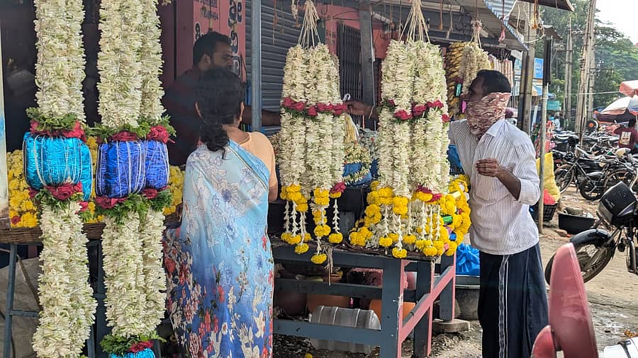 ಚಾಮರಾಜನಗರದ ಹೂವಿನ ಮಾರುಕಟ್ಟೆಯಲ್ಲಿ ಹೂ ಖರೀದಿಯಲ್ಲಿ ನಿರತರಾಗಿರುವ ಗ್ರಾಹಕರು