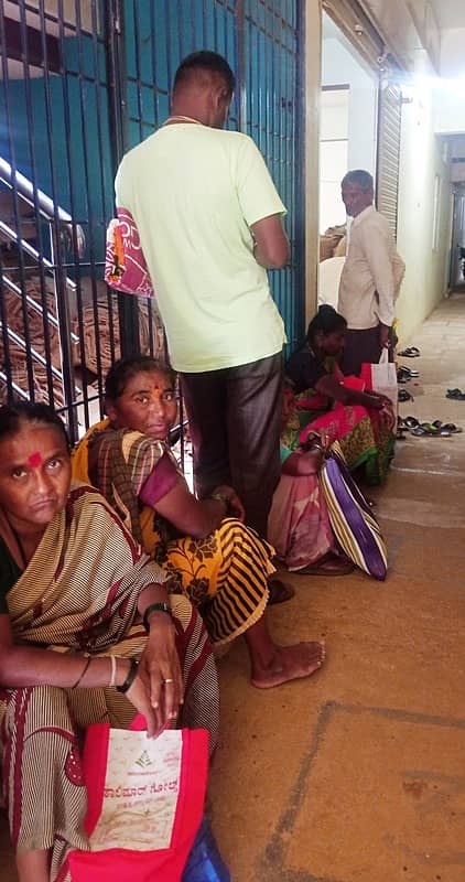 ರಟ್ಟೀಹಳ್ಳಿ ಪಟ್ಟಣದ ಪಡಿತರ ವಿತರಣೆ ಕೇಂದ್ರದಲ್ಲಿ ರೇಷನ್ ಪಡೆಯಲು ಜನರು ಸರತಿಯಲ್ಲಿ ಗಂಟೆಗಟ್ಟಲೆ ಕಾಯುತ್ತಿರುವುದು