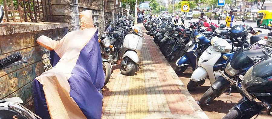 ತುಮಕೂರು ವಿ.ವಿ ಮುಂಭಾಗದಲ್ಲಿರುವ ಫುಟ್ಪಾತ್ನಲ್ಲಿ ಬೈಕ್ ನಿಲ್ಲಿಸಿರುವುದು