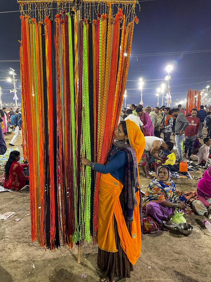 <div class="paragraphs"><p>ಮಹಾಕುಂಭ ಮೇಳದಲ್ಲಿ ಮಹಿಳೆಯೊಬ್ಬರು ದಾರಗಳನ್ನು ಮಾರುತ್ತಿರುವುದು</p></div>